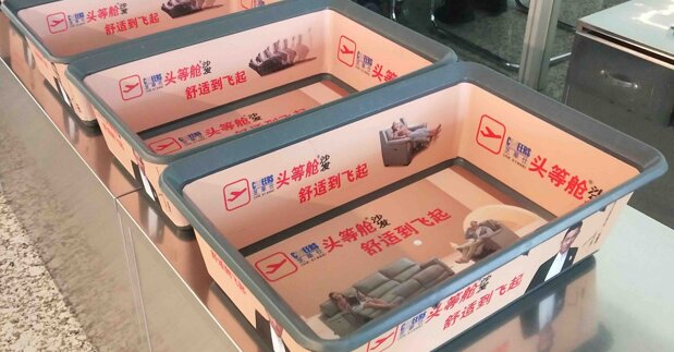 第一户外传媒-温州龙湾机场T2国内出发安检区域安检筐贴画广告