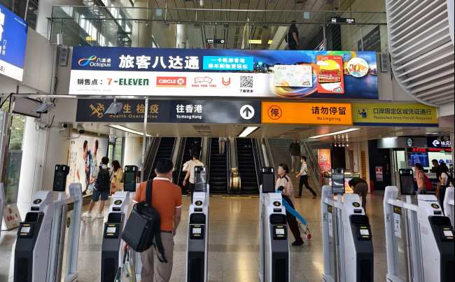 深圳福田口岸往香港通道上方的旅客八达通广告位，展示八达通卡的便利服务