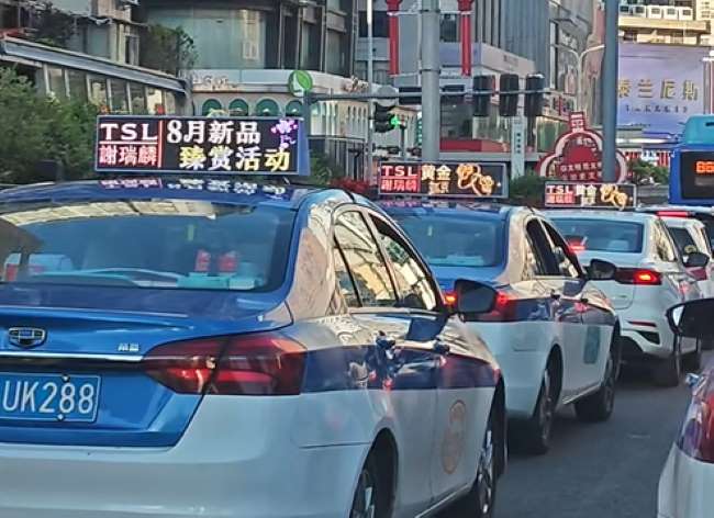 贵阳街头出租车排队等红灯中，车顶LED彩屏也联排播放谢瑞麟广告