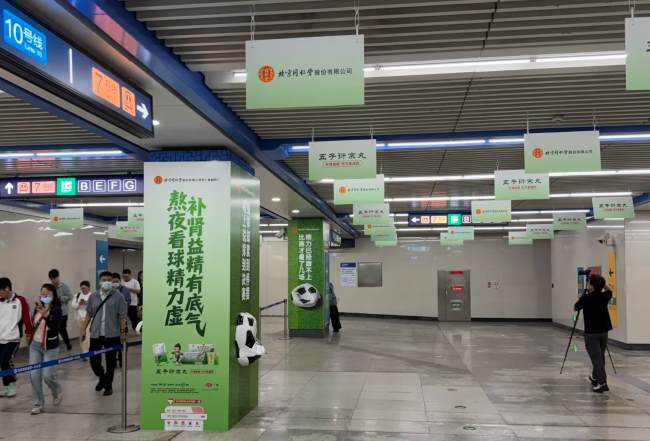 北京地铁双井站路人纷纷自发拍摄世界杯足球相关宣传广告贴纸画面