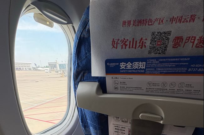 好客山东欢迎您，山东航空头枕巾广告刊登着本地酱酒品牌，云门酱酒