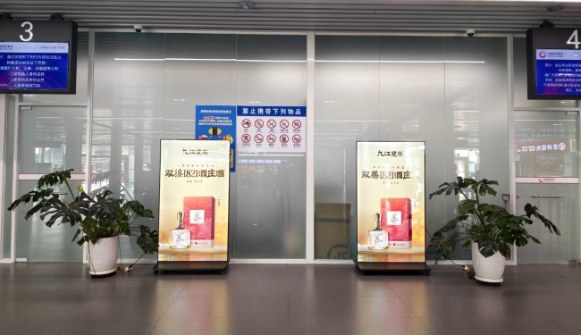 佛山机场出发大厅安检口选用磨砂玻璃墙与候机厅阻隔，图为安检口前刷屏机LED广告大屏 