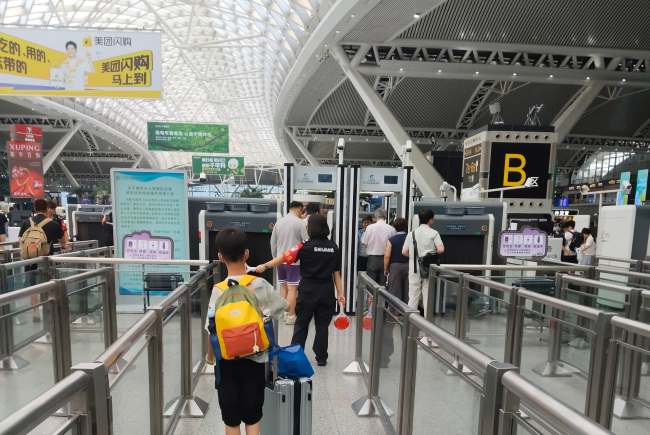 广州南站三层候车大厅进站口排队安检由外向内拍摄实拍图，服务台在安检口内侧的候车大厅中央位置 