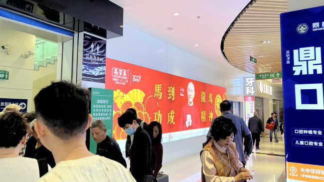 深圳莲塘口岸商业城通道口岸连接处的墙面2026年初刊登着香港品牌马百良广告画面