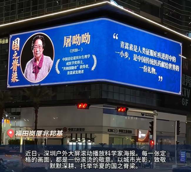 近日，深圳户外大屏滚动播放科学家海报，图为福田兆邦基金融大厦外墙折角裸眼3D大屏，展示屠呦呦青蒿素