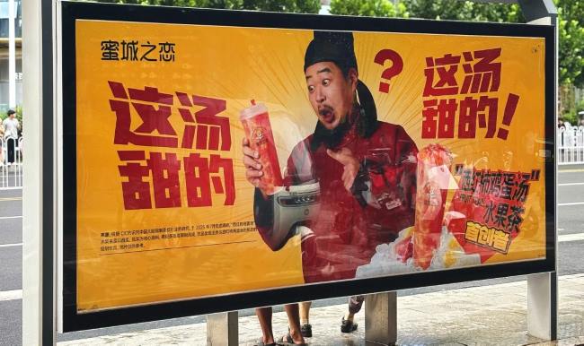 图为徐州候车亭站牌，刊登着古装卡通人物形象的蜜城之恋西红柿鸡蛋汤广告画面