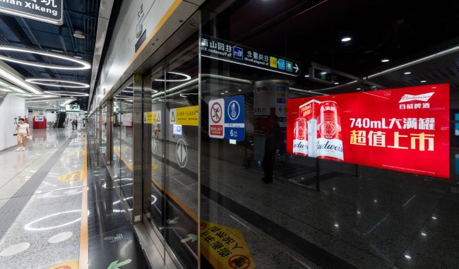 图为大运站站台轨行区的灯箱广告画面，百威啤酒新品上市广告案例图